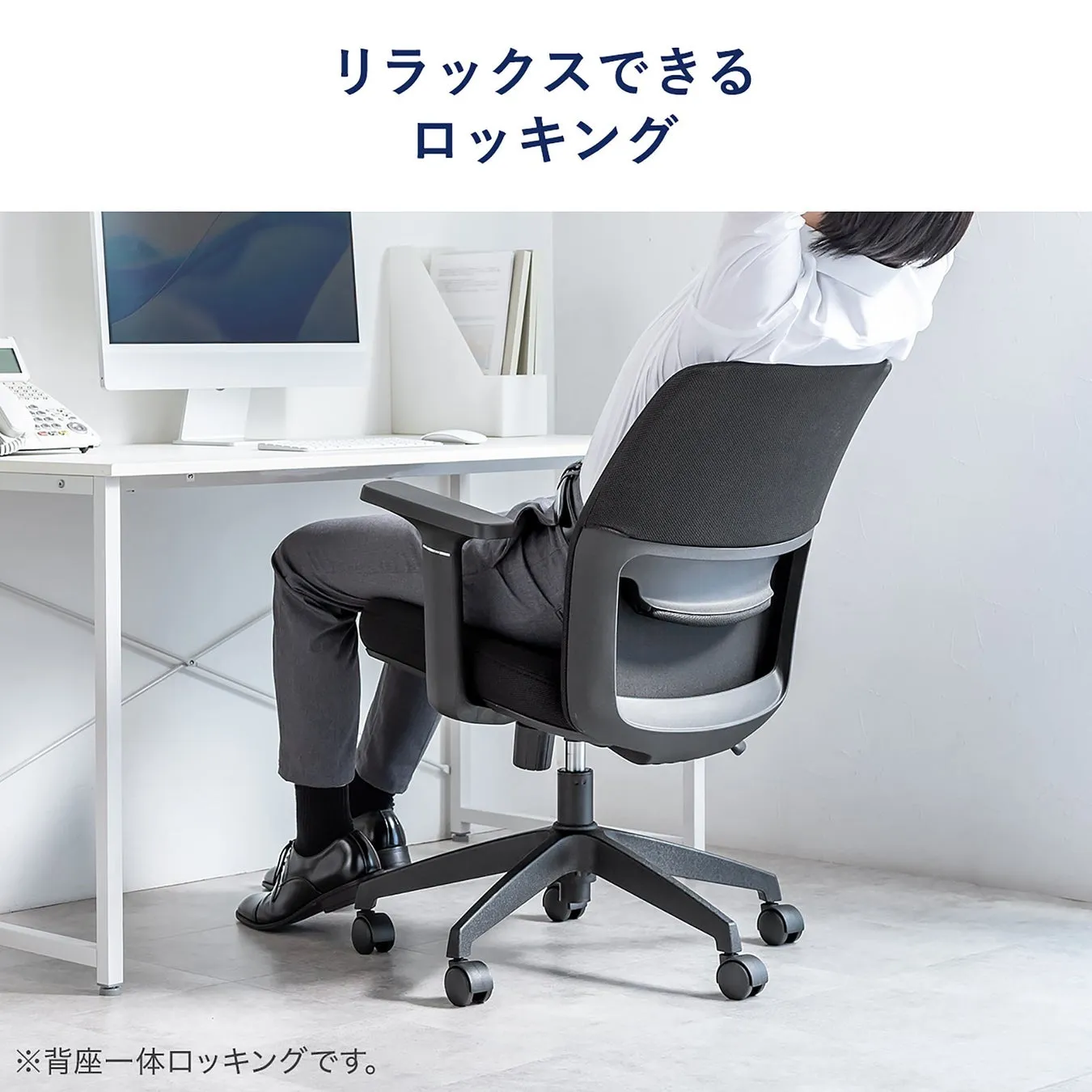 オフィスチェアに座り、リラックスしている男性の写真。