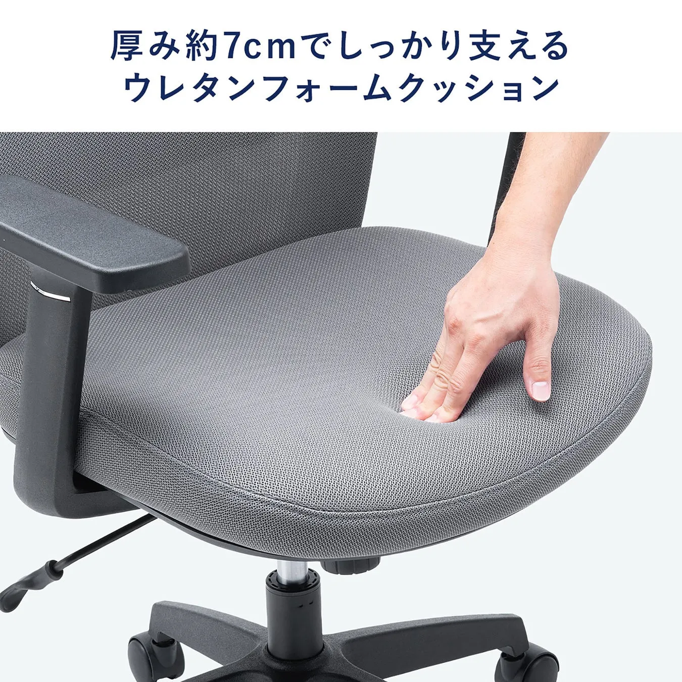 椅子に座っている人の手で、椅子のクッションが押されている様子が写っています。