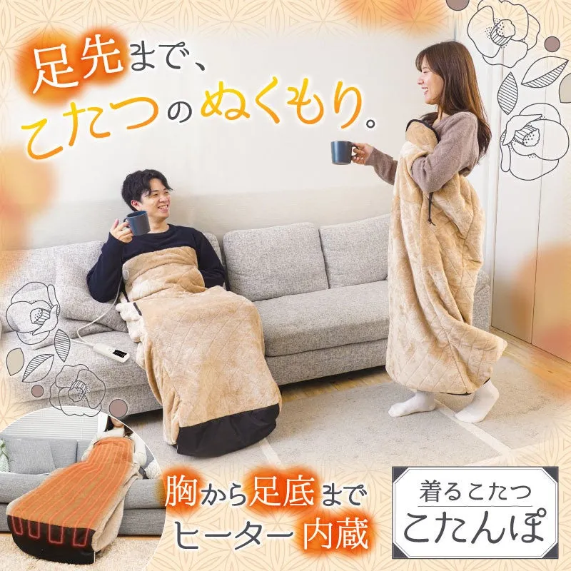 暖房器具の広告。男性がこたつに入り、女性がこたつを持っている。