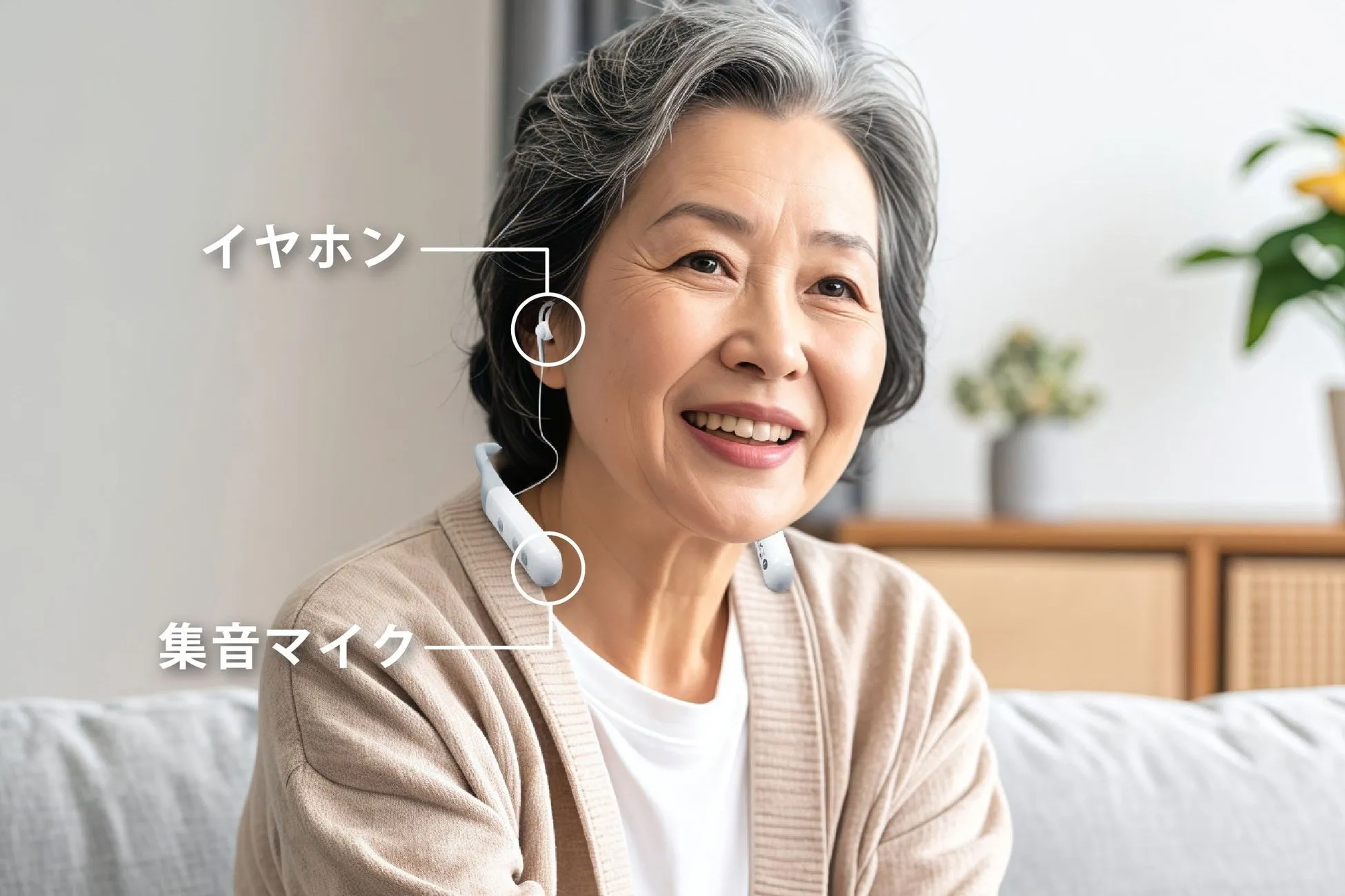 笑顔の高齢女性が、首掛け式の集音マイクとイヤホンを装着している様子