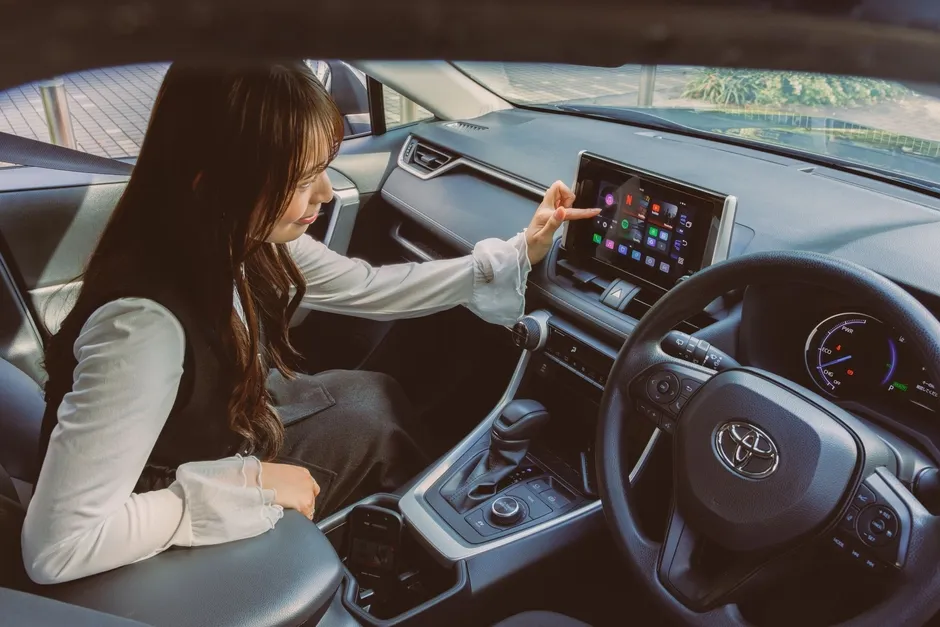 車内で女性がナビゲーションシステムを操作している様子。