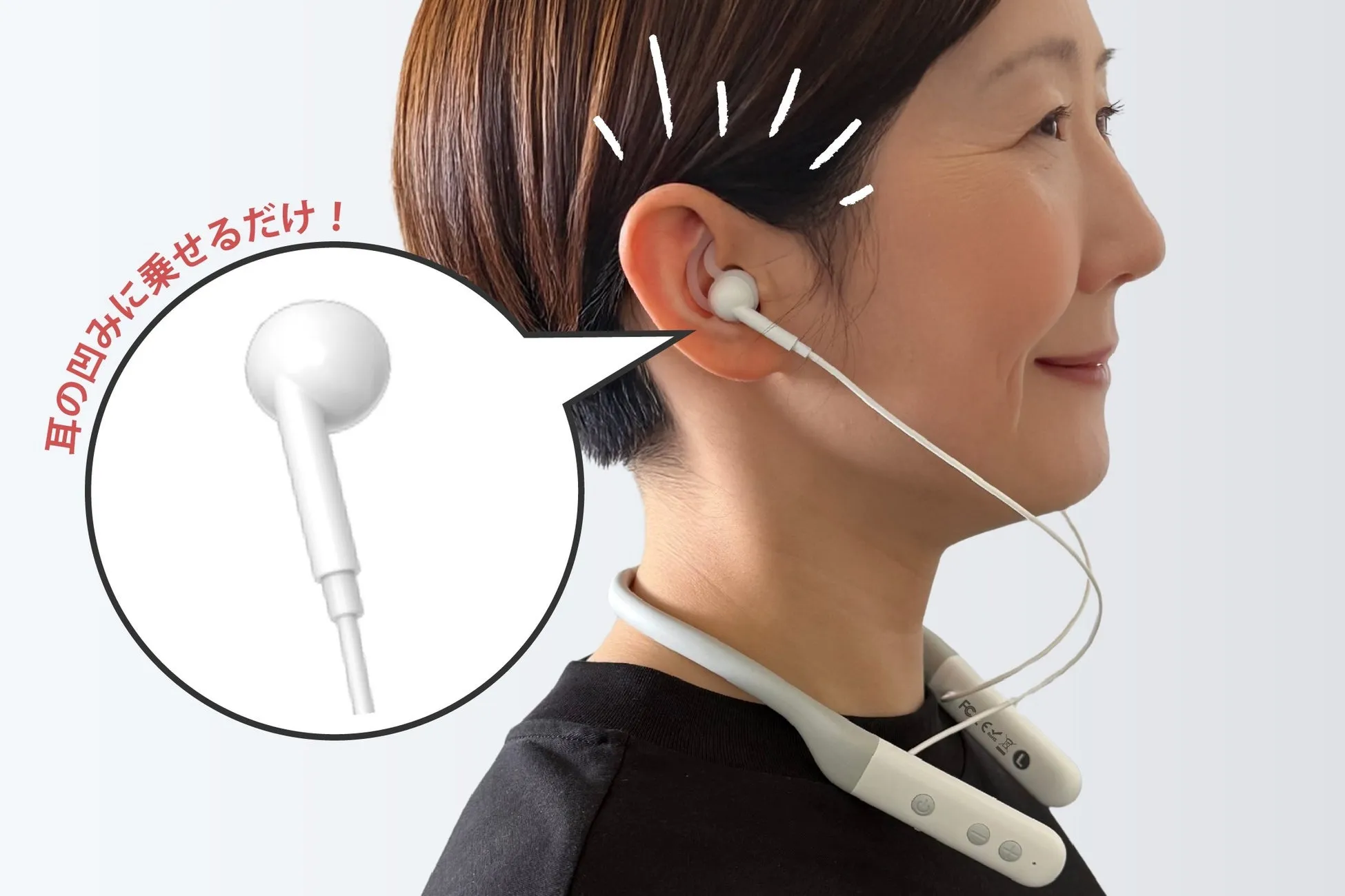 女性が首掛け式のイヤホンを耳のくぼみに乗せて装着している様子