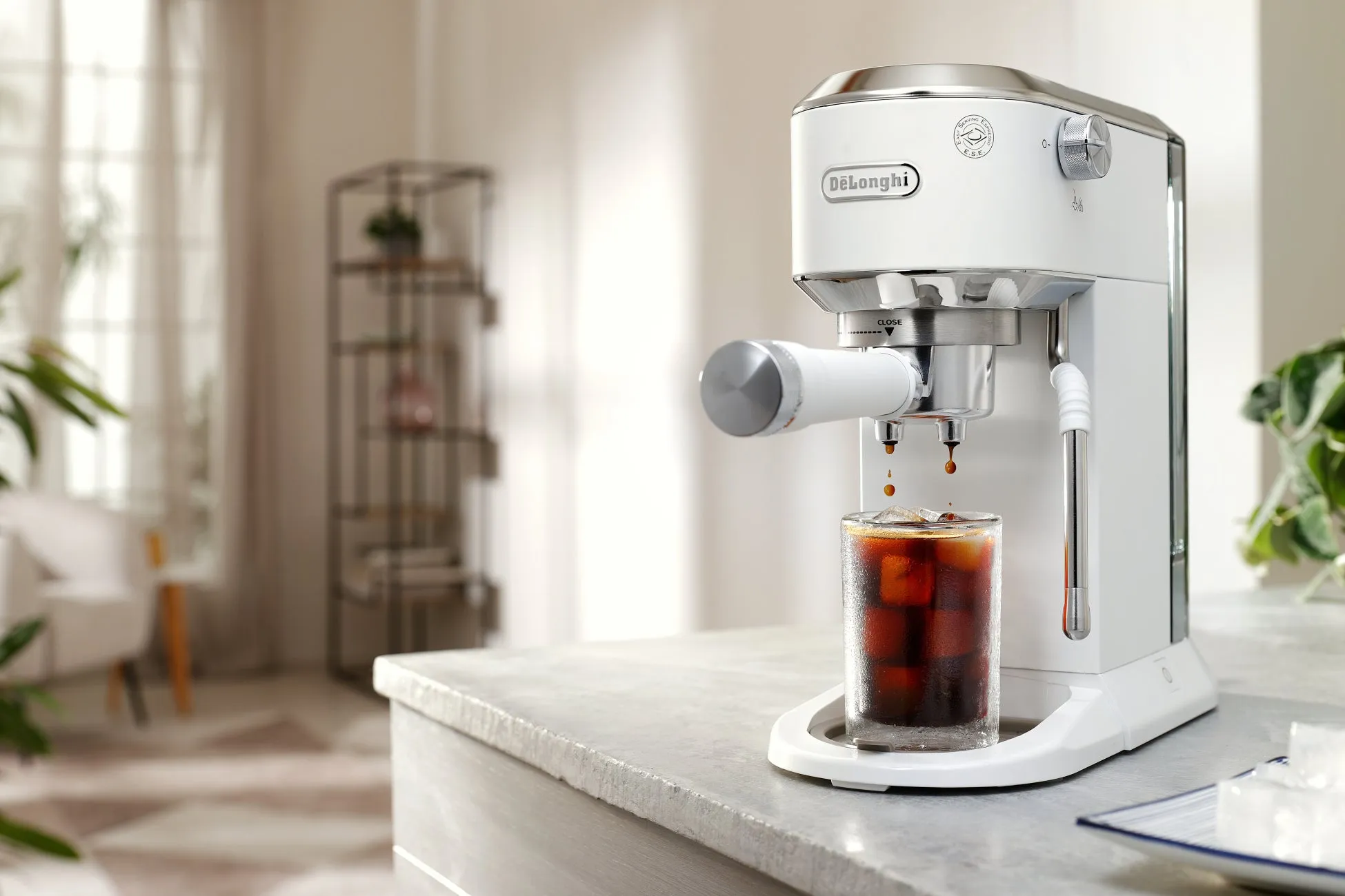 デロンギのコーヒーメーカーが、氷の入ったグラスにコーヒーを抽出している様子