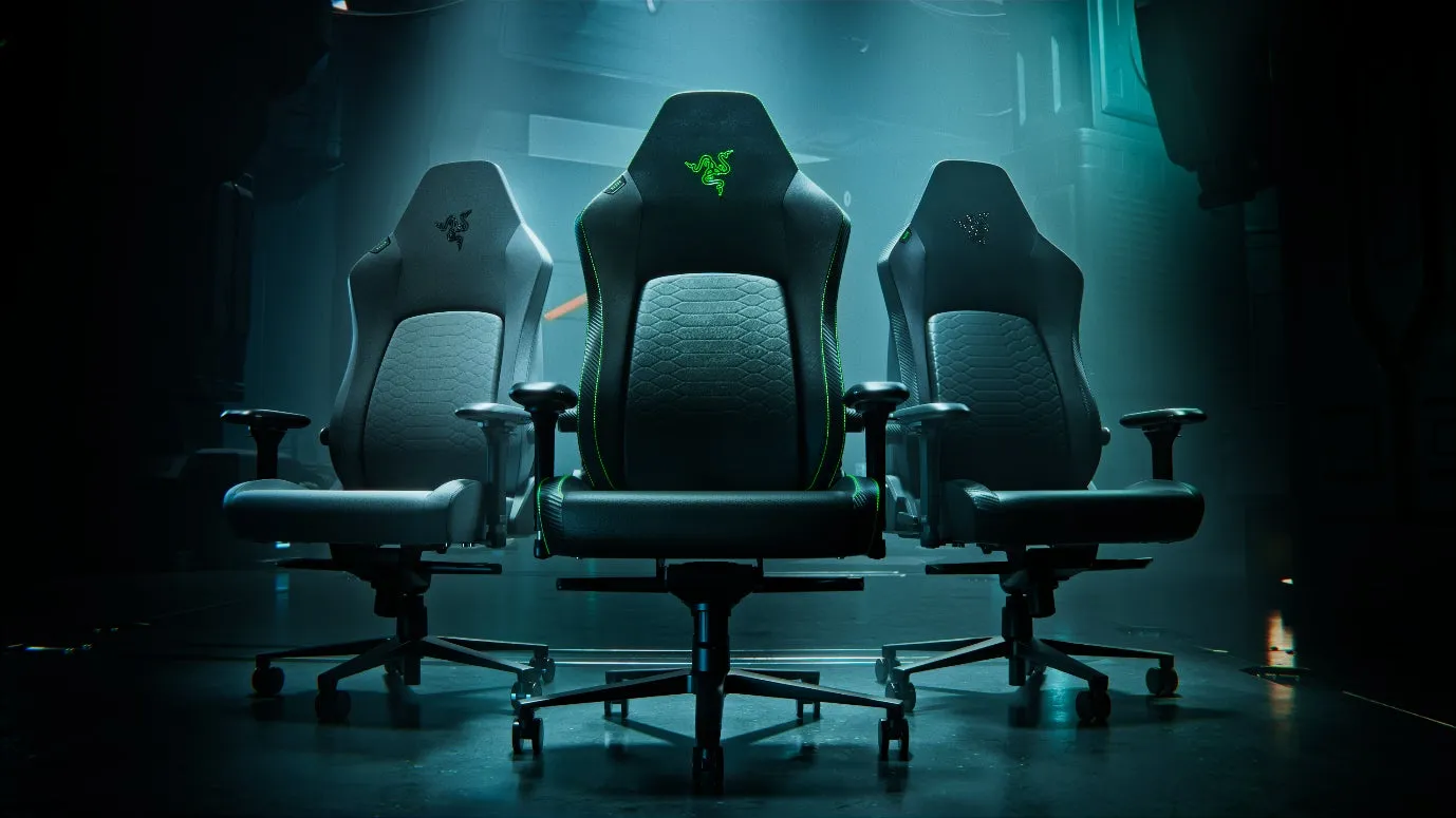 Razerのゲーミングチェアが3脚並んでいる画像です。中央のチェアは黒色で、Razerのロゴが緑色に光っています。両側のチェアはグレーです。
